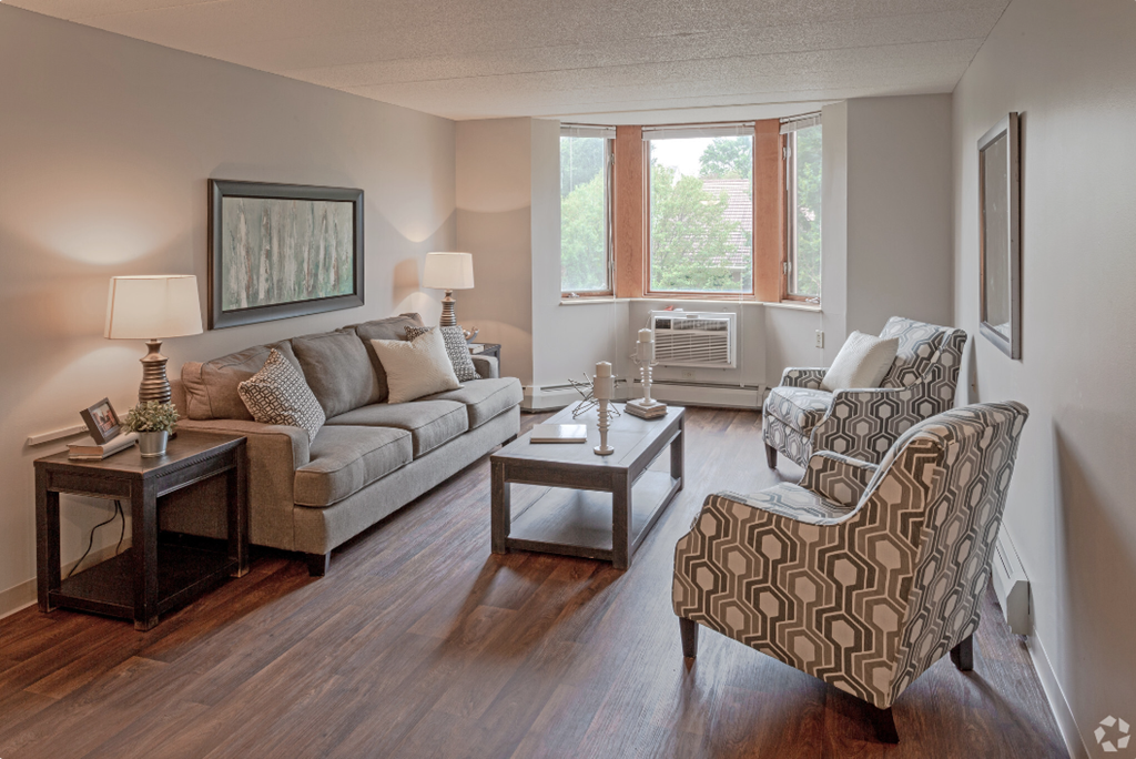 a living room with couches and chairs and a window