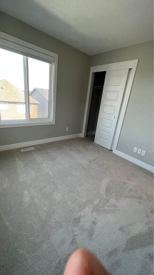 an empty living room with a large window and a door