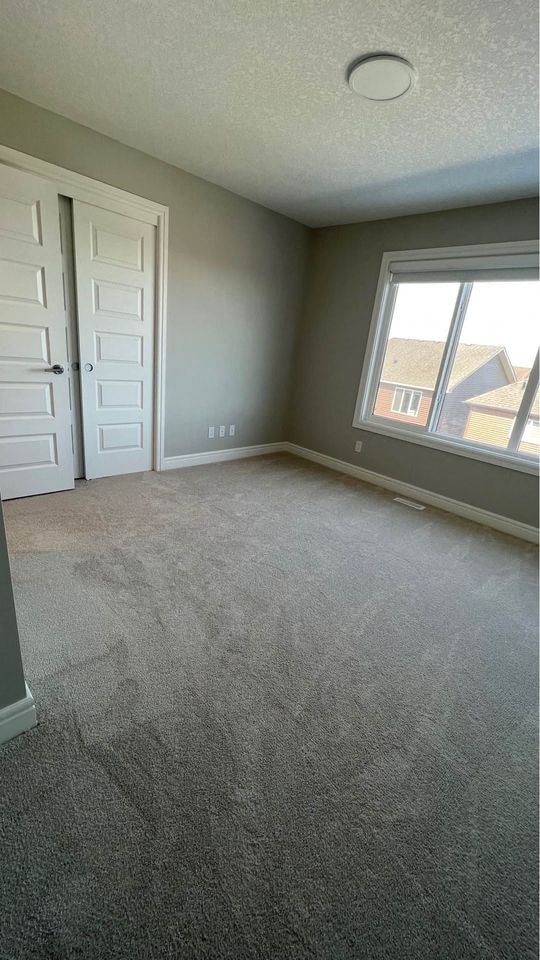 an empty living room with a window and a door