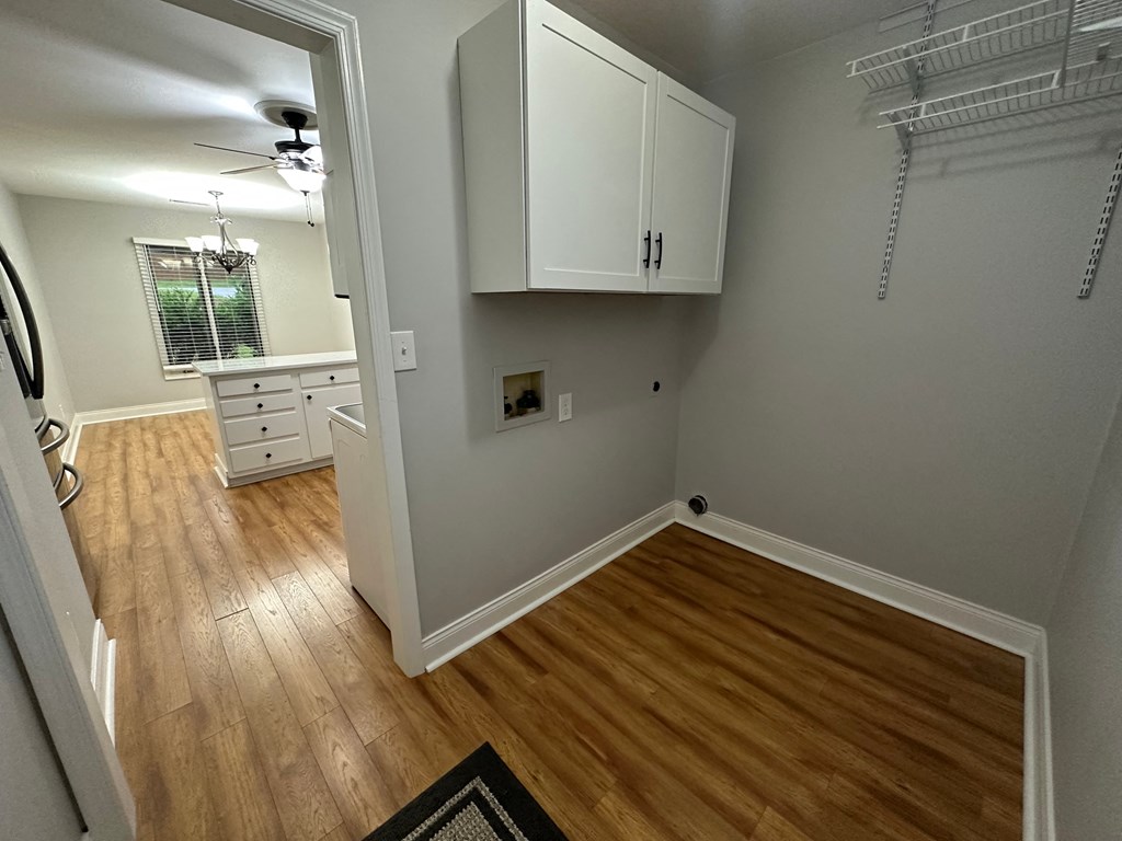 a living room with a hard wood floor and white cabinets