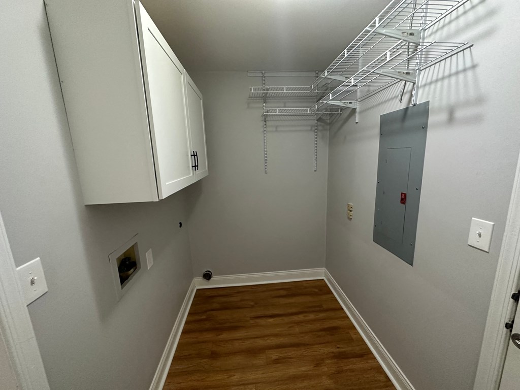 a room with a wood floor and a closet with white cabinets
