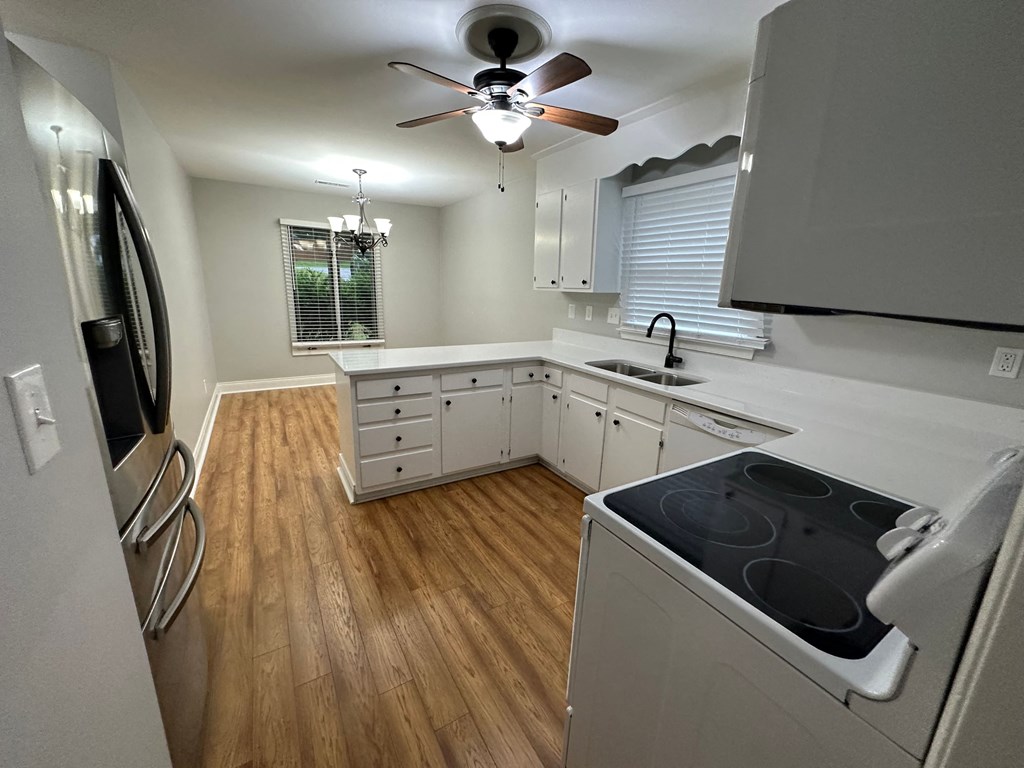a kitchen with a stove and a ceiling fan