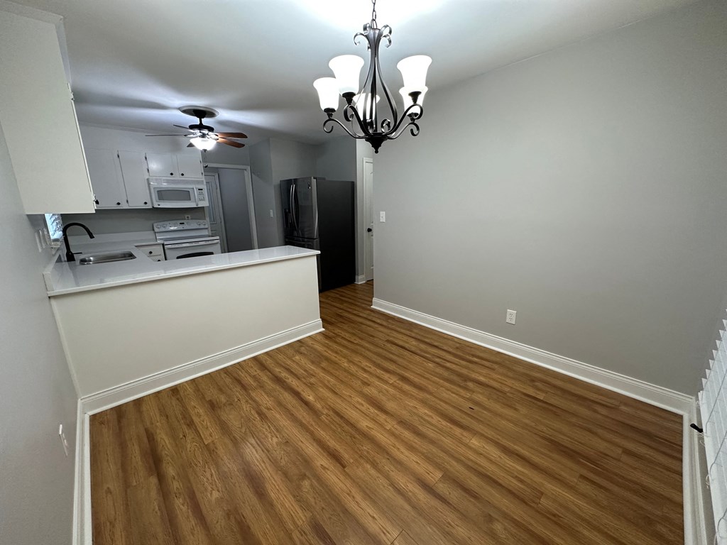 a renovated living room with a kitchen and wood flooring