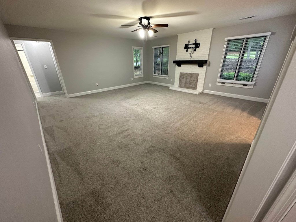 a empty living room with a ceiling fan