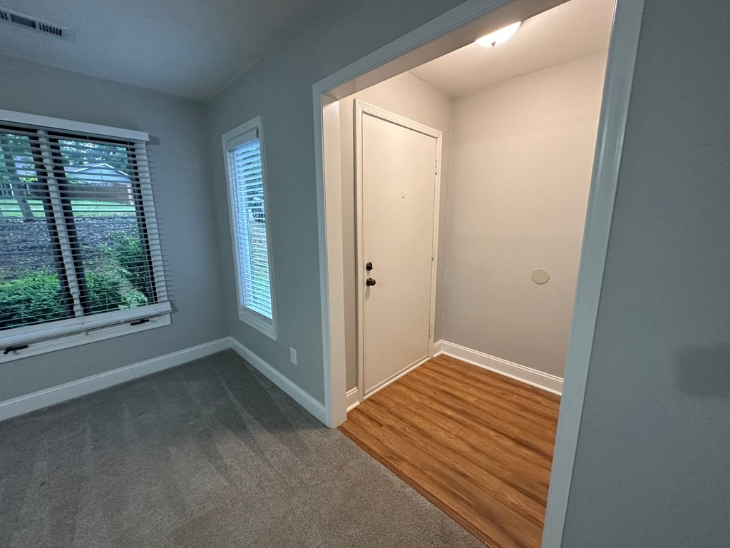 a bedroom with a door to a closet and a window