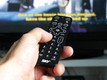 hand holding remote pointing it at TV