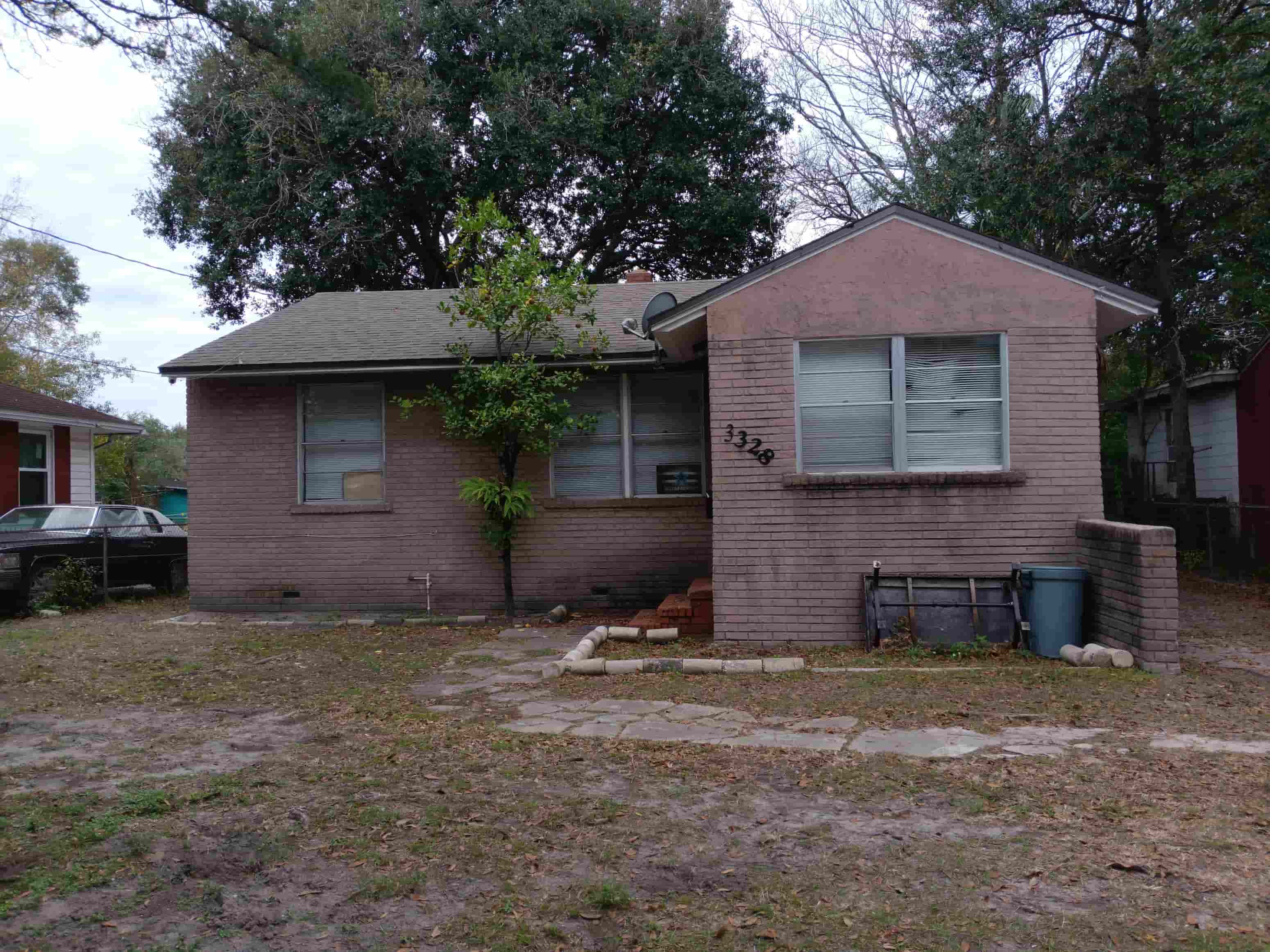 a small brick house with a yard in front of it