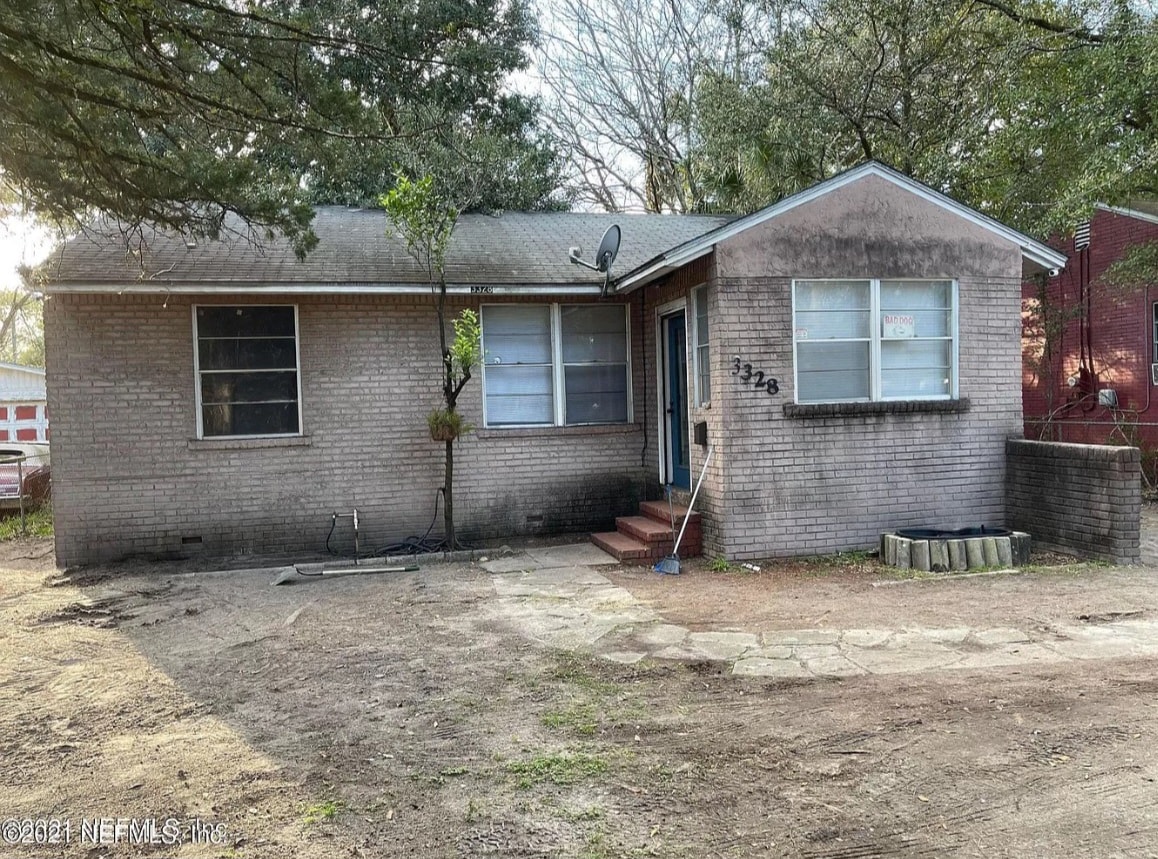 the front of a brick house with a dirt yard