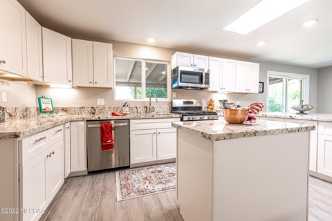 a large kitchen with white cabinets and granite counter tops