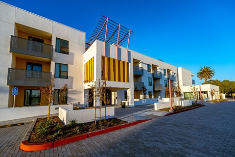 A modern building with a red brick walkway in front.