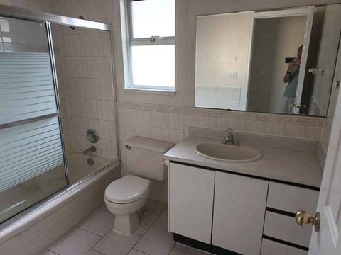A bathroom with a toilet, sink, and shower.