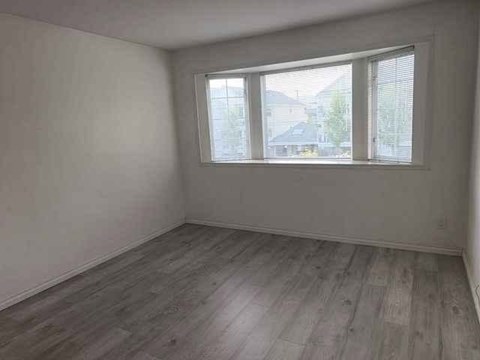 A room with a window and wooden flooring.