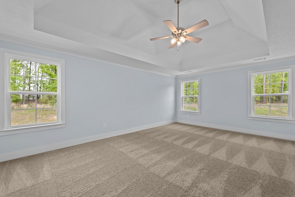 an empty living room with two windows and a ceiling fan