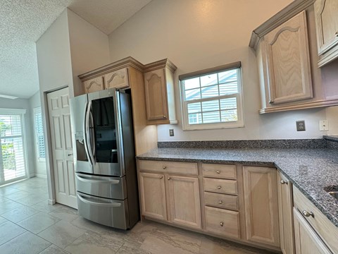 a kitchen with wooden cabinets and a stainless steel refrigerator
