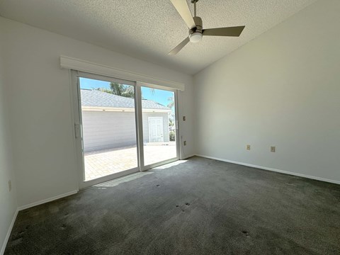 a living room with a ceiling fan and a sliding glass door