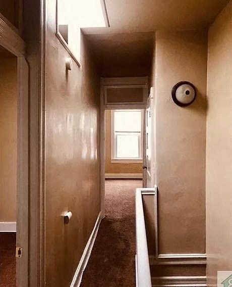 a hallway with a staircase and a window