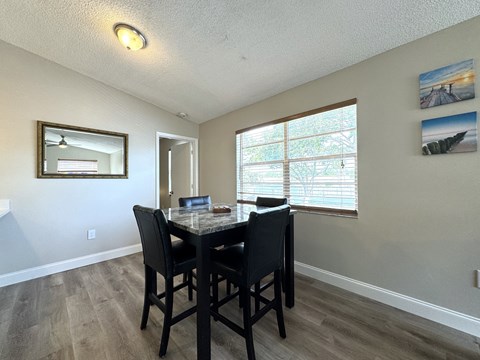 a dining room with a table and chairs and a window