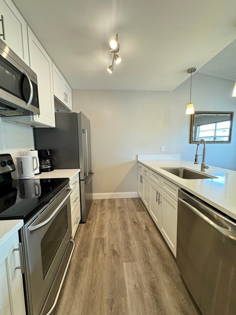 a kitchen with stainless steel appliances and white cabinets