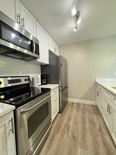 a kitchen with stainless steel appliances and white cabinets