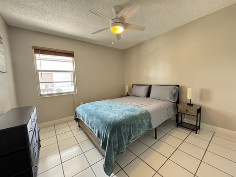 a bedroom with a bed and a ceiling fan