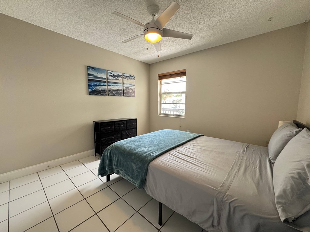 a bedroom with a bed and a ceiling fan