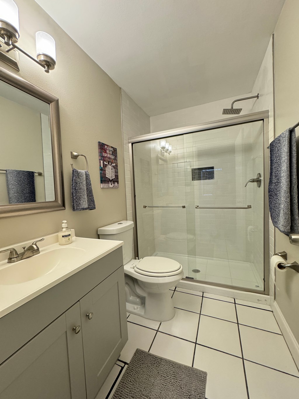 a bathroom with a shower and a sink and a toilet