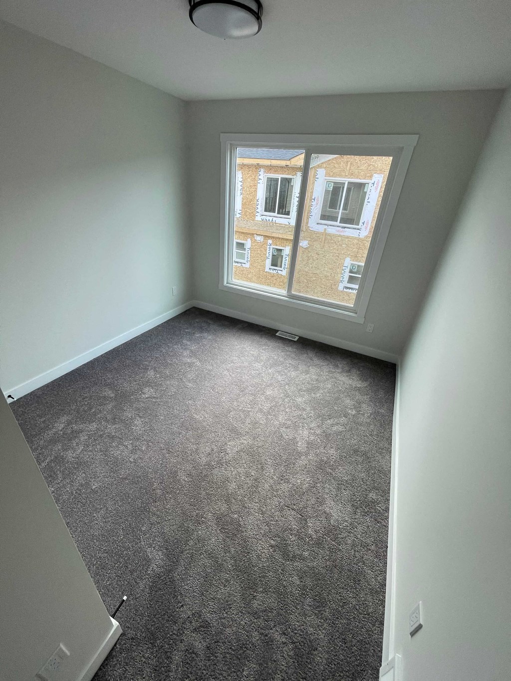 a empty room with a window and carpeted floor