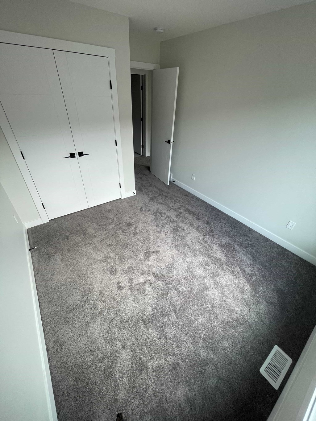 a carpeted room with white closets and a carpet floor