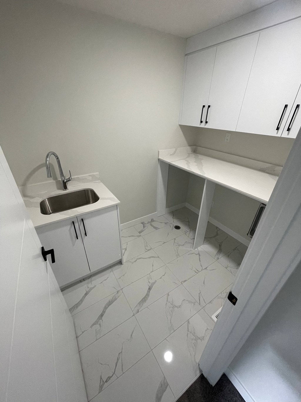 an empty kitchen with white cabinets and a sink
