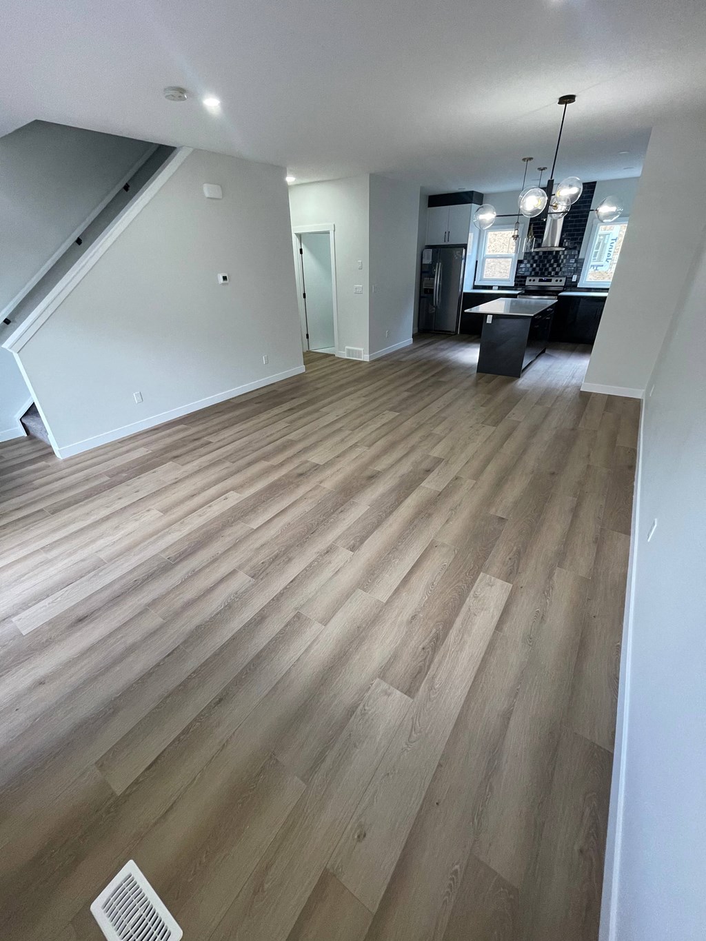a renovated living room with hardwood floors and white walls