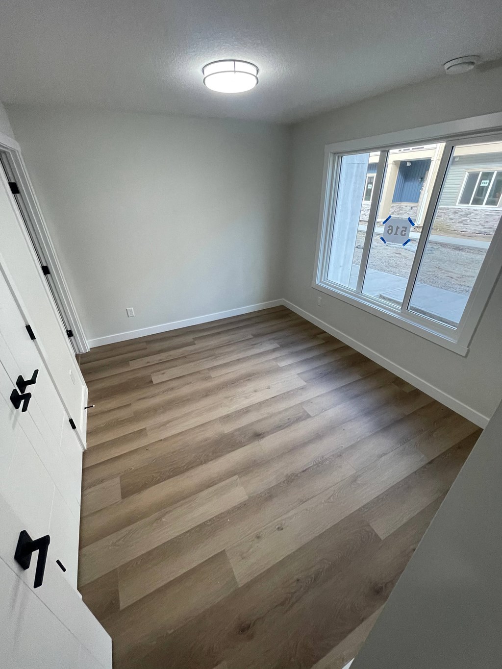 a renovated living room with hardwood floors and a window