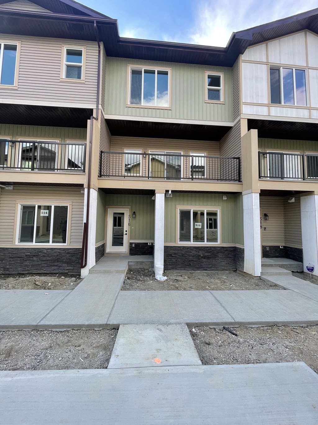 an apartment building with a sidewalk in front of it