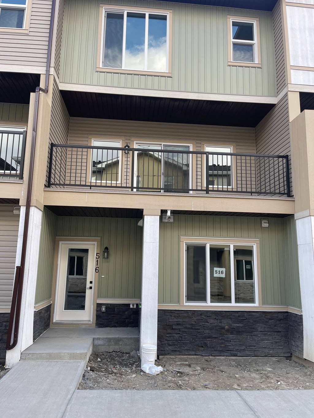the front of a green house with a balcony