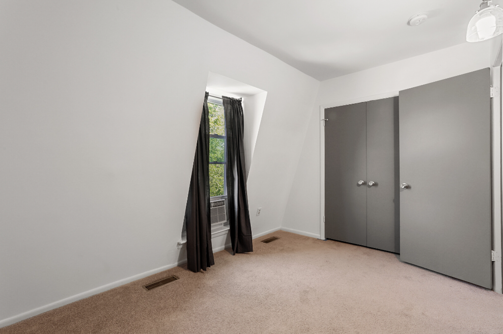 an empty room with gray walls and a door to a closet