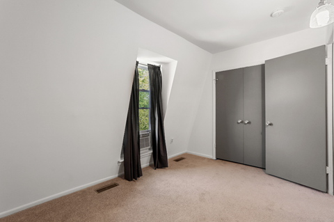 an empty room with gray walls and a door to a closet
