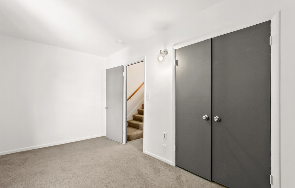 a bedroom with two doors and a staircase in a house