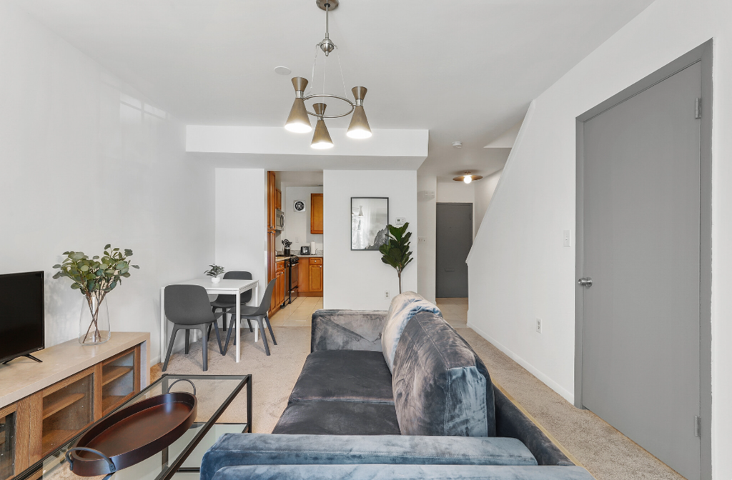 a living room with a blue couch and a dining room table