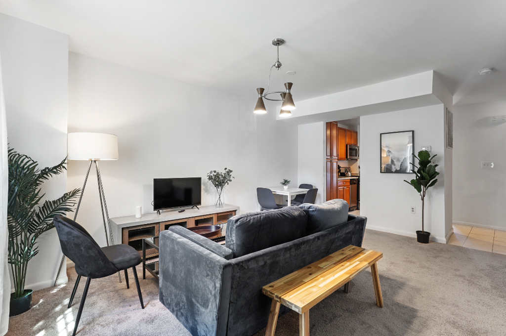 a living room with a couch and a desk with a tv