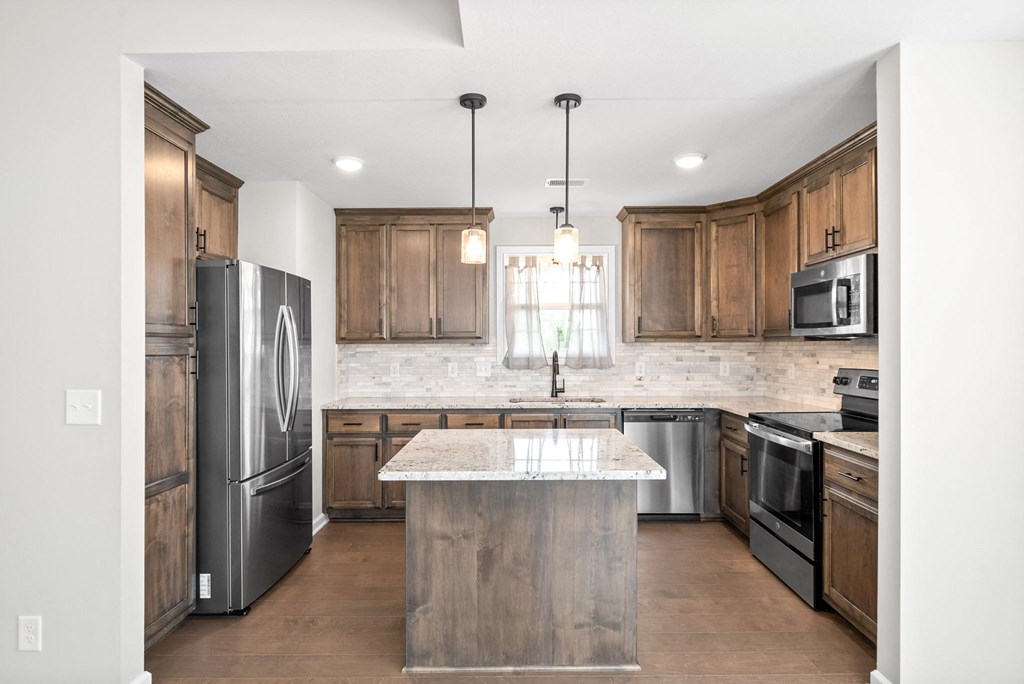 a kitchen with wooden cabinets and stainless steel appliances