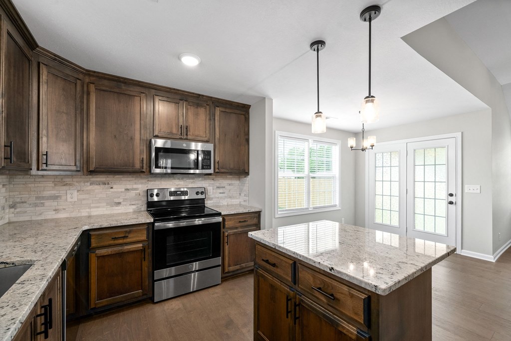 a kitchen with wooden cabinets and a marble counter top