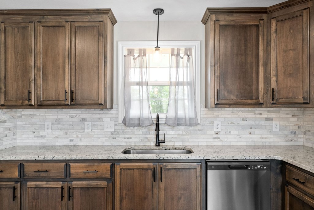 a kitchen with wood cabinets and a sink and a window