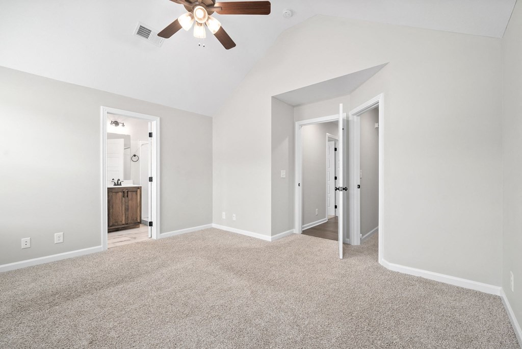 an empty living room with white walls and a ceiling fan