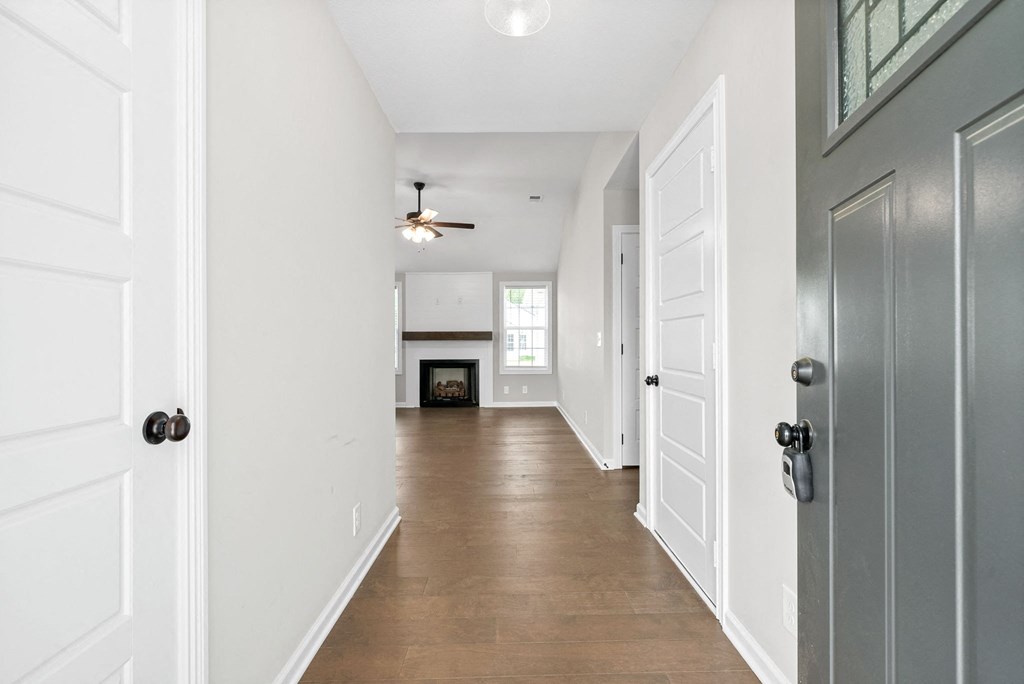 an empty living room with white walls and a ceiling fan