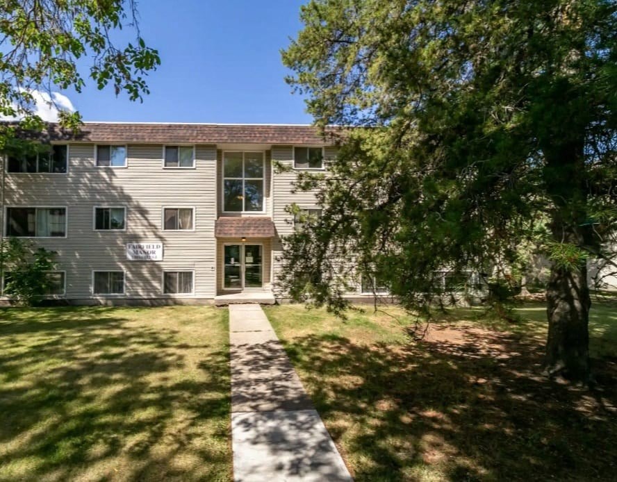 a house with a sidewalk and trees in front of it