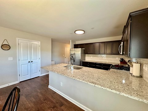 a kitchen with a granite counter top and a stainless steel refrigerator