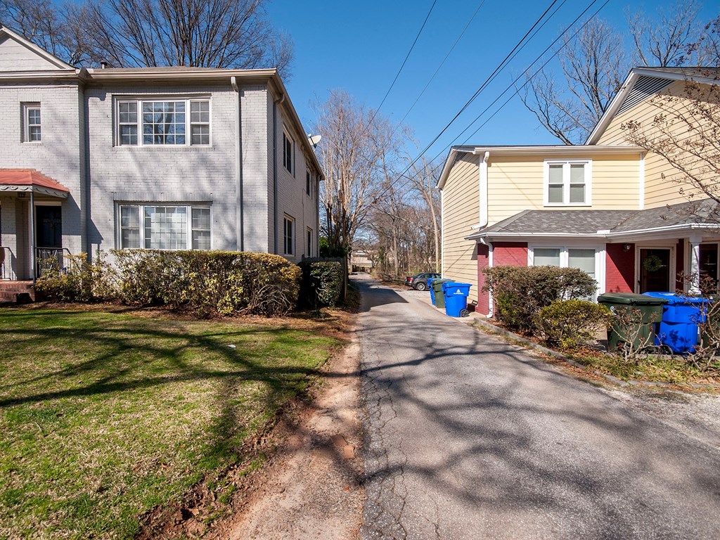 two houses on the side of a street next to a sidewalk