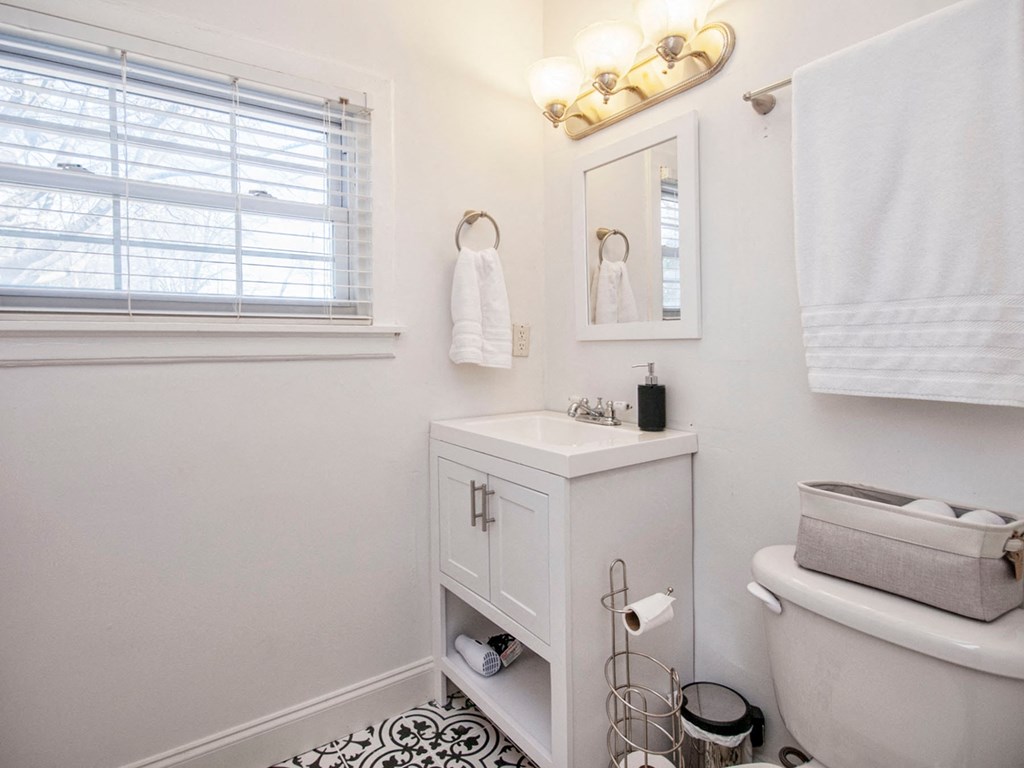a small bathroom with a toilet and a sink and a window
