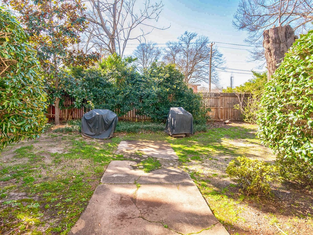 a backyard with two tarp tents on the grass