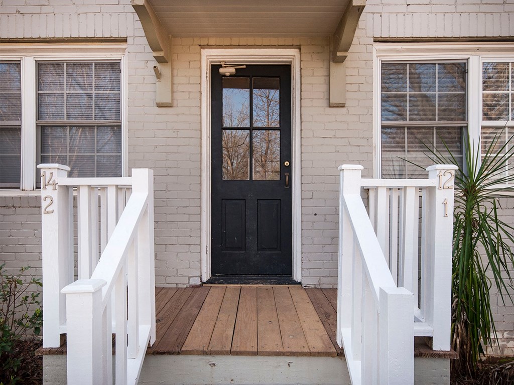 a house with a black door and a porch