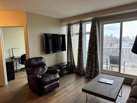 a living room with a large window and a chair and a table